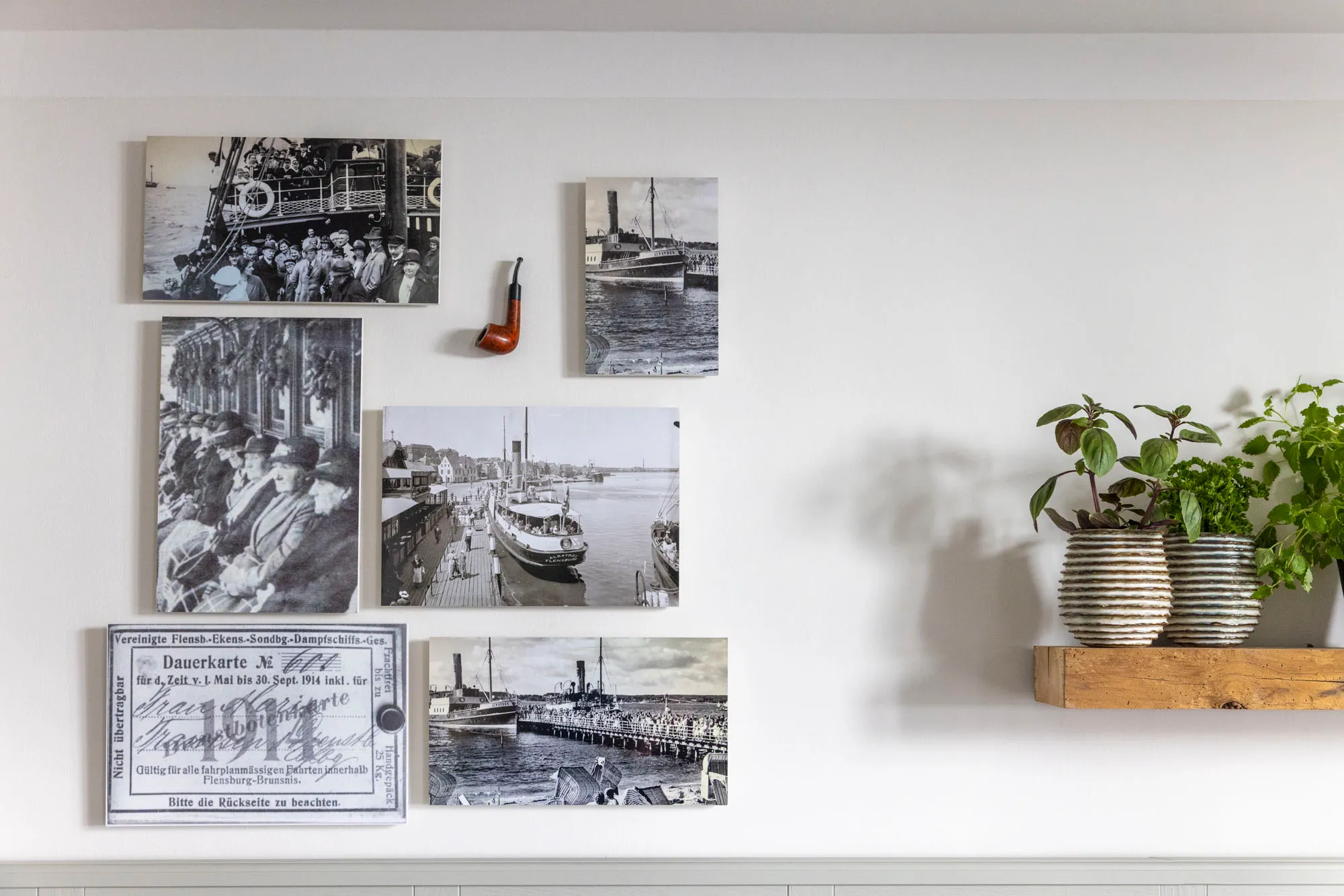 Historisches Hafenbild und Kapitänsmütze über dem Bett